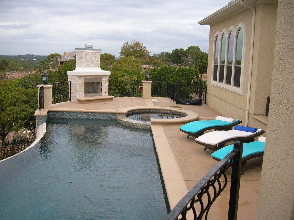 Idée de décoration pour une grande piscine à débordement minimaliste sur mesure avec du béton estampé.