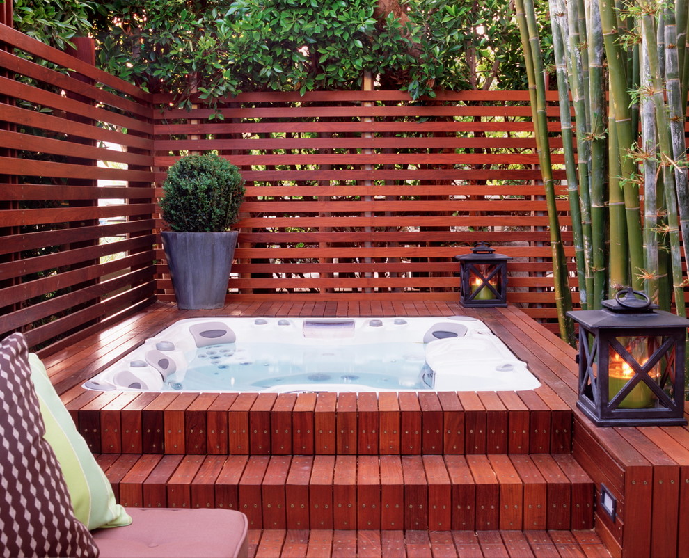 Пример оригинального дизайна: наземный бассейн среднего размера на заднем дворе в современном стиле с джакузи и настилом