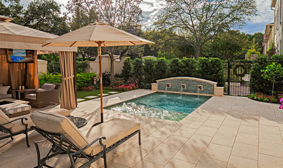 Diseño de piscina con fuente tradicional pequeña rectangular en patio delantero con adoquines de piedra natural