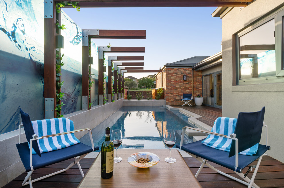 Foto de casa de la piscina y piscina infinita de tamaño medio rectangular en patio con entablado