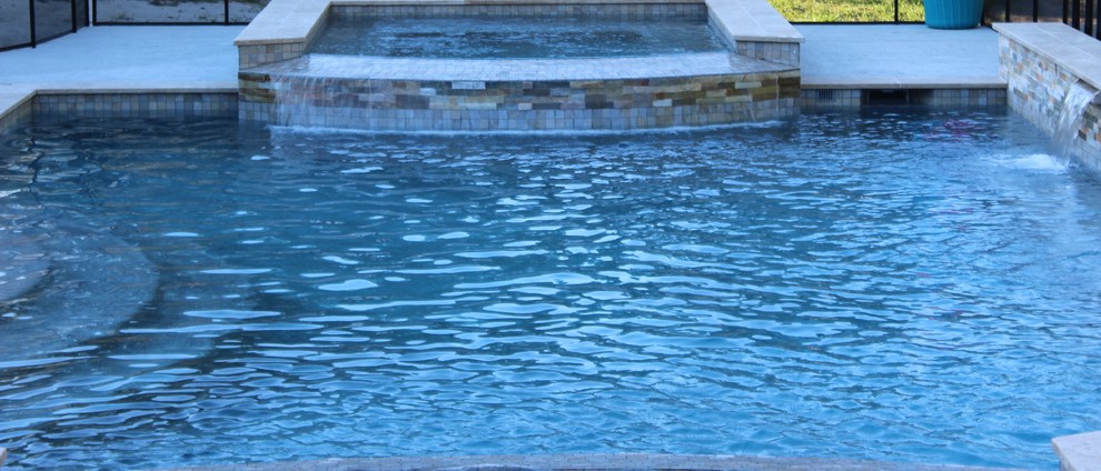 Esempio di una piscina naturale minimalista rettangolare di medie dimensioni e dietro casa con una vasca idromassaggio e pavimentazioni in cemento