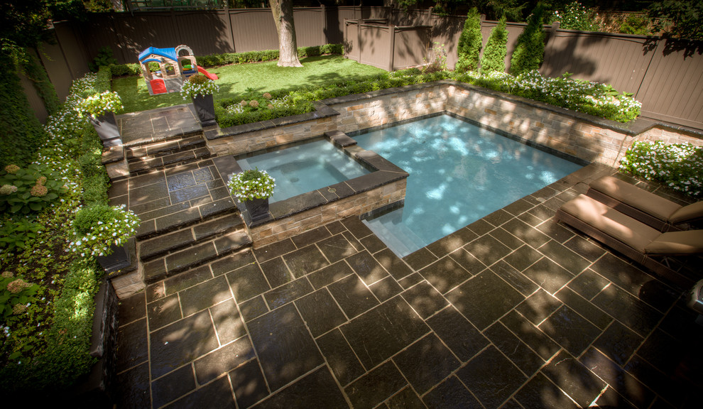 Immagine di una piscina monocorsia classica personalizzata di medie dimensioni e dietro casa con una vasca idromassaggio e pavimentazioni in pietra naturale