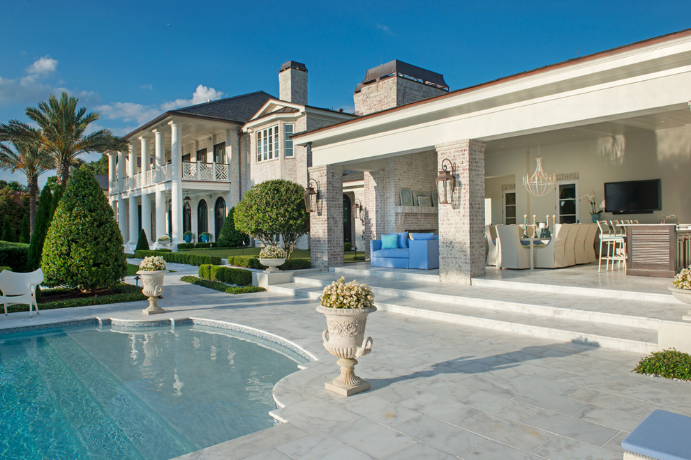 Example of a huge classic backyard stone and custom-shaped lap pool design in Orlando