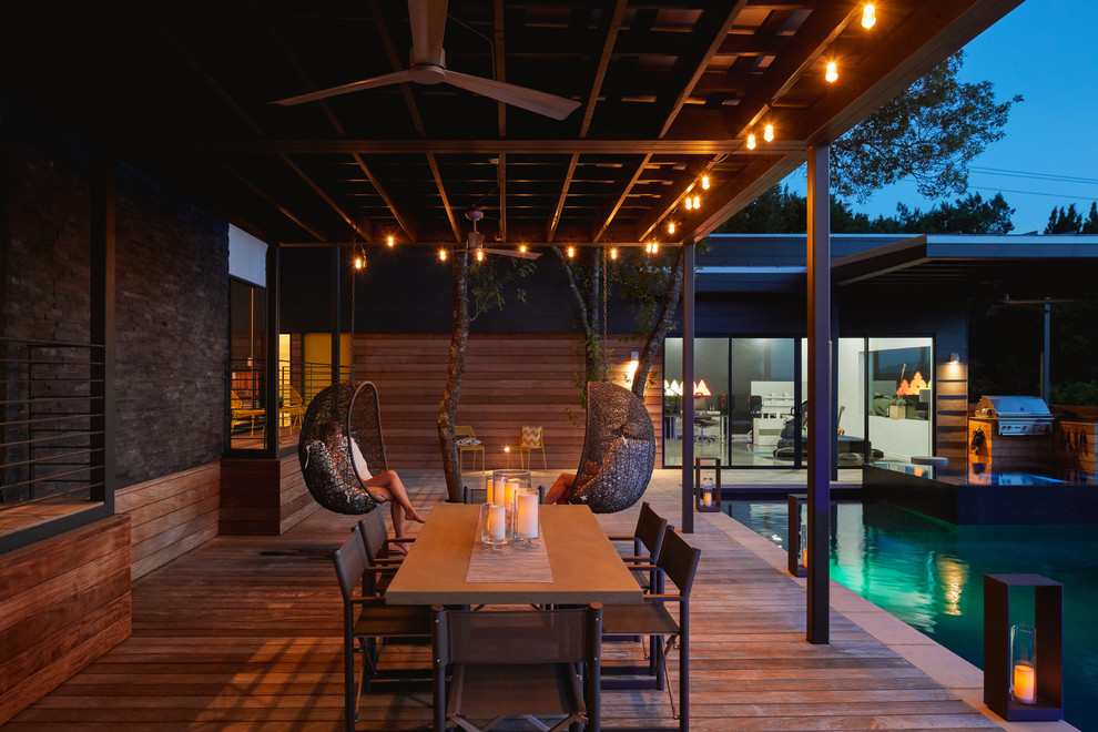 Cette image montre une piscine design en L avec une cour et une terrasse en bois.