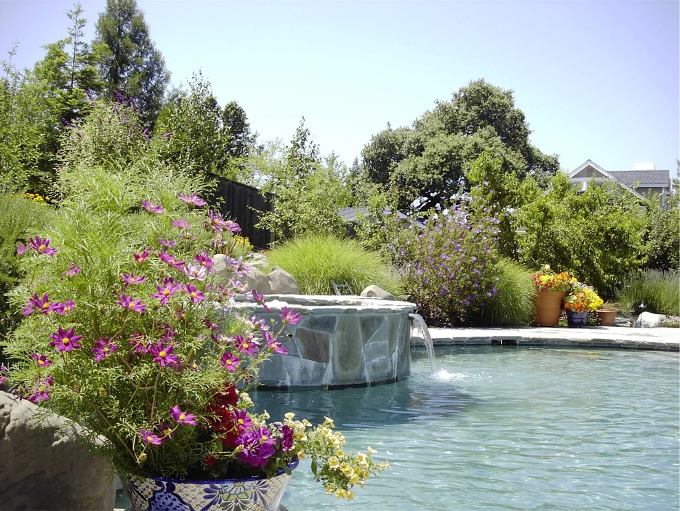 Esempio di una grande piscina naturale vittoriana personalizzata dietro casa con una vasca idromassaggio e pavimentazioni in pietra naturale