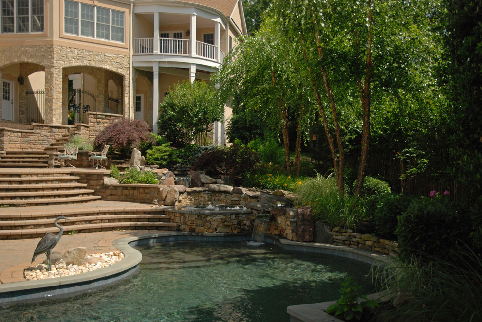 Idee per una piscina naturale bohémian personalizzata di medie dimensioni e dietro casa con fontane e pavimentazioni in cemento