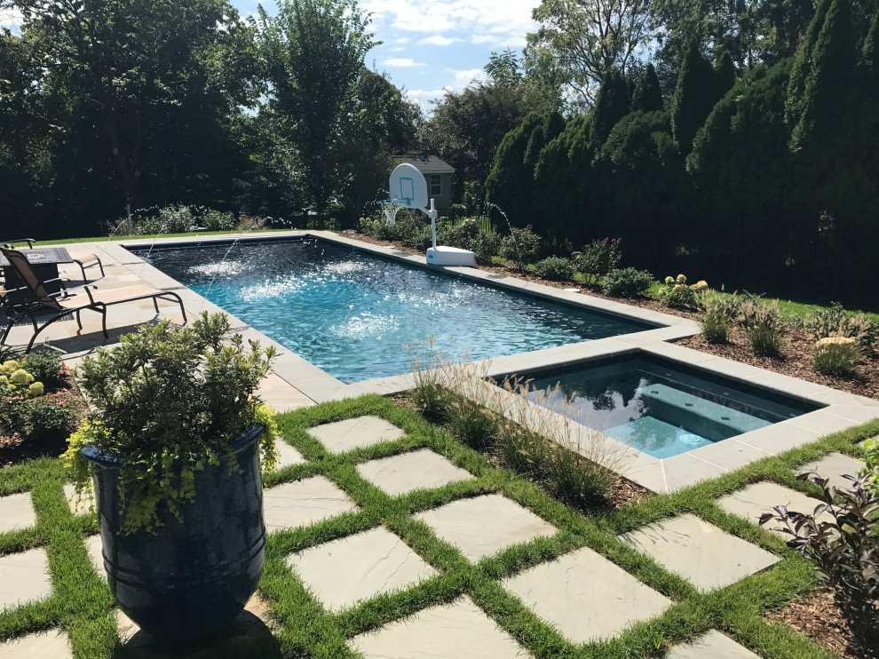 На фото: прямоугольный бассейн среднего размера на заднем дворе с покрытием из каменной брусчатки с