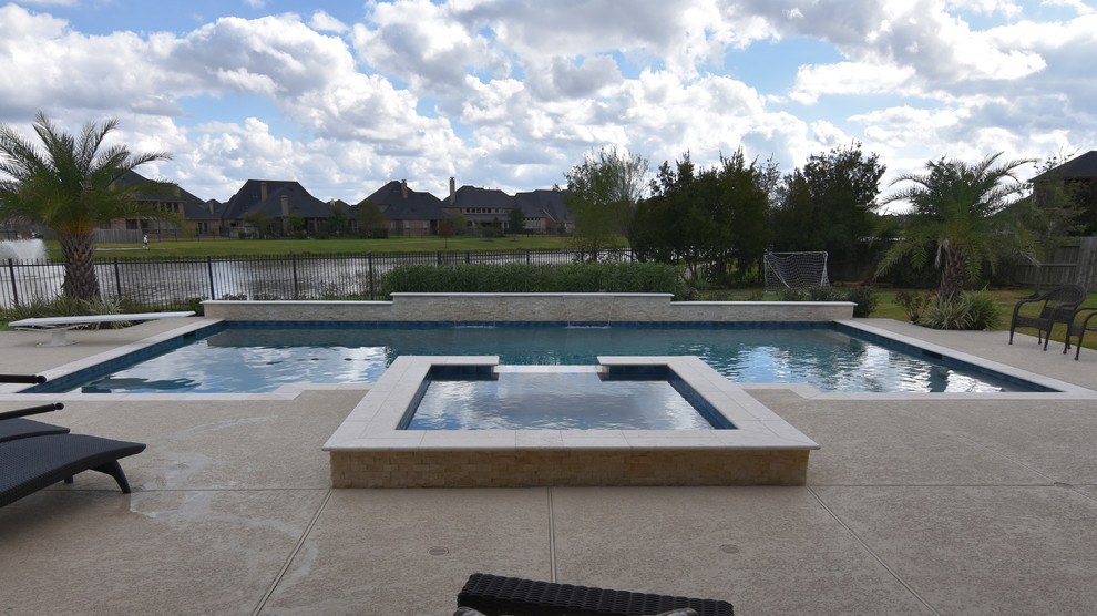 Cette photo montre une grande piscine arrière moderne rectangle avec une terrasse en bois.