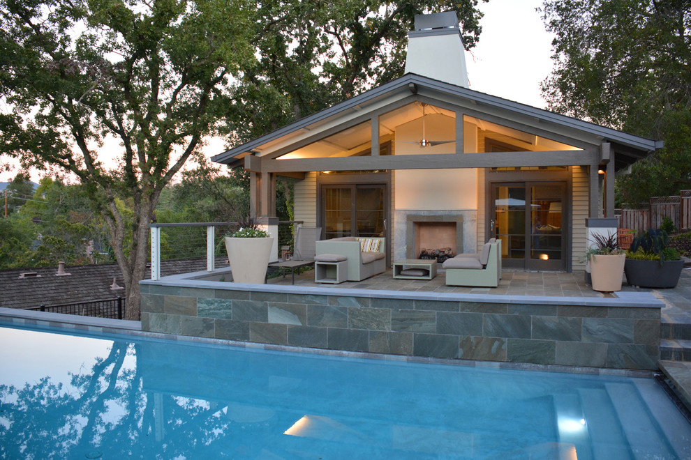 Diseño de casa de la piscina y piscina alargada contemporánea grande rectangular en patio trasero con adoquines de piedra natural