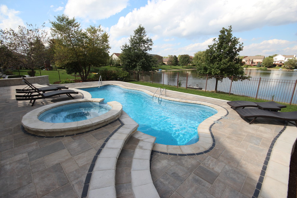 Imagen de piscinas y jacuzzis alargados contemporáneos grandes a medida en patio trasero con adoquines de ladrillo