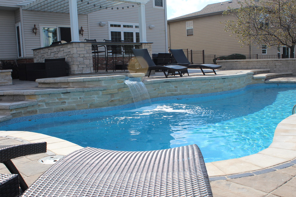Ejemplo de piscinas y jacuzzis alargados contemporáneos grandes a medida en patio trasero con adoquines de ladrillo
