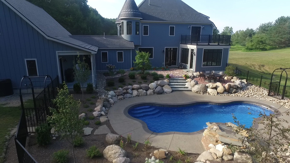 Идея дизайна: бассейн среднего размера, произвольной формы на заднем дворе в викторианском стиле с покрытием из бетонных плит