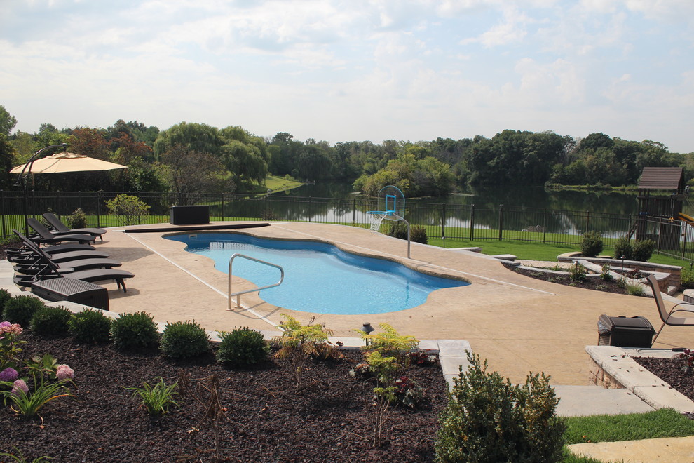 Immagine di una grande piscina classica personalizzata dietro casa con cemento stampato