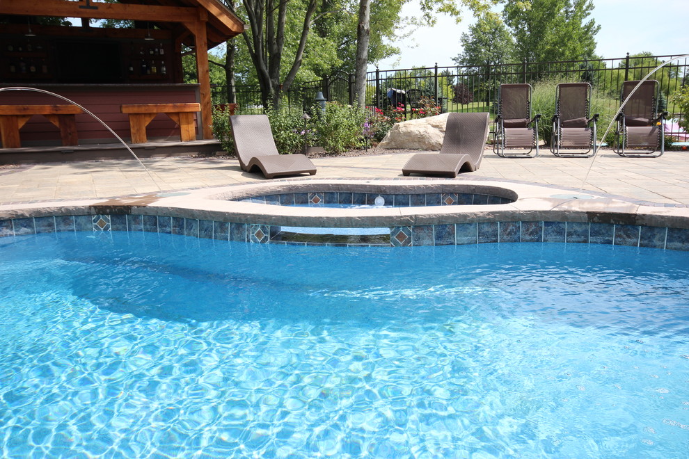 Diseño de piscinas y jacuzzis alargados contemporáneos grandes a medida en patio trasero con adoquines de ladrillo