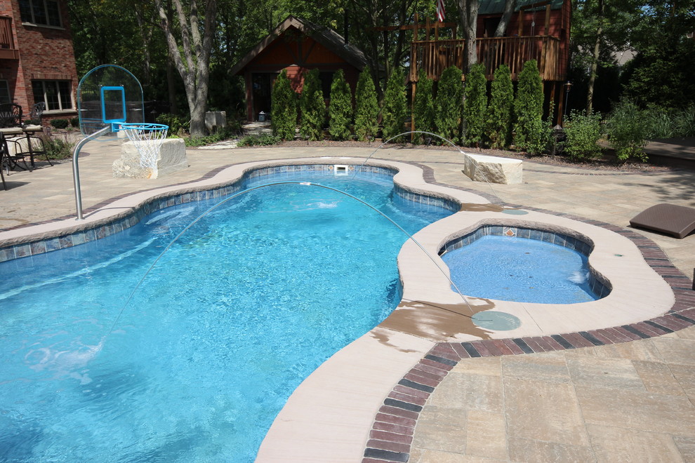 Ispirazione per una grande piscina monocorsia minimal personalizzata dietro casa con una vasca idromassaggio e pavimentazioni in mattoni