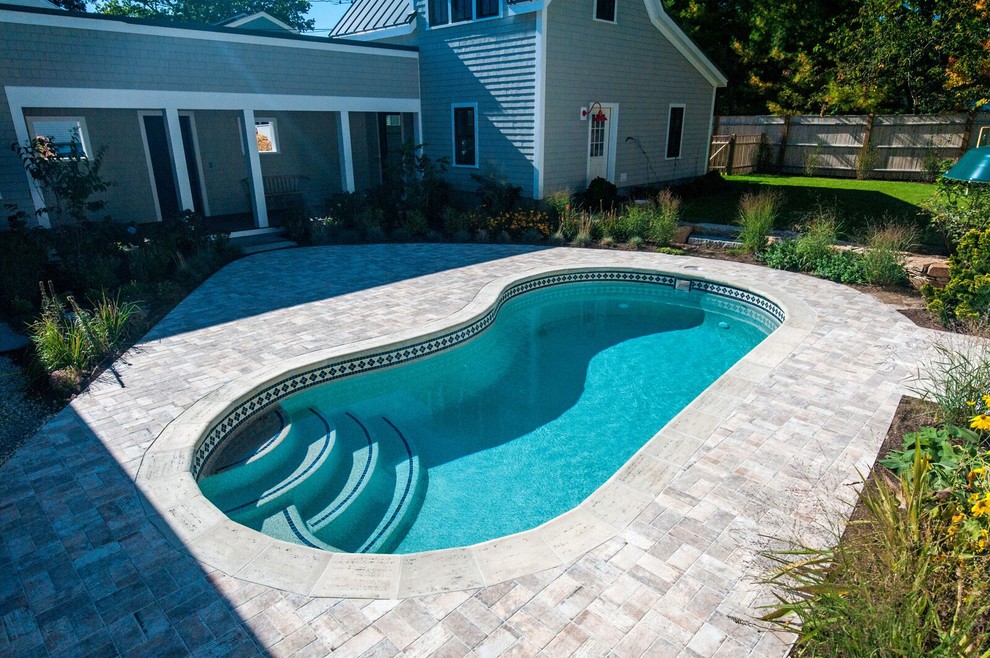 Esempio di una piccola piscina moderna a "C" dietro casa con pavimentazioni in mattoni