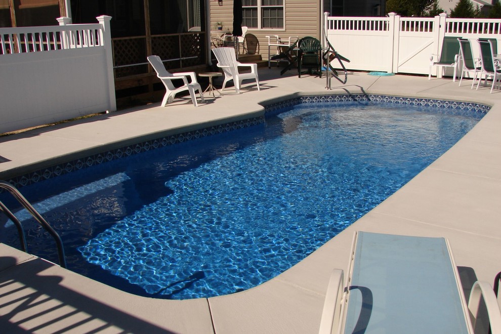 Идея дизайна: бассейн среднего размера, произвольной формы на заднем дворе в современном стиле с покрытием из бетонных плит
