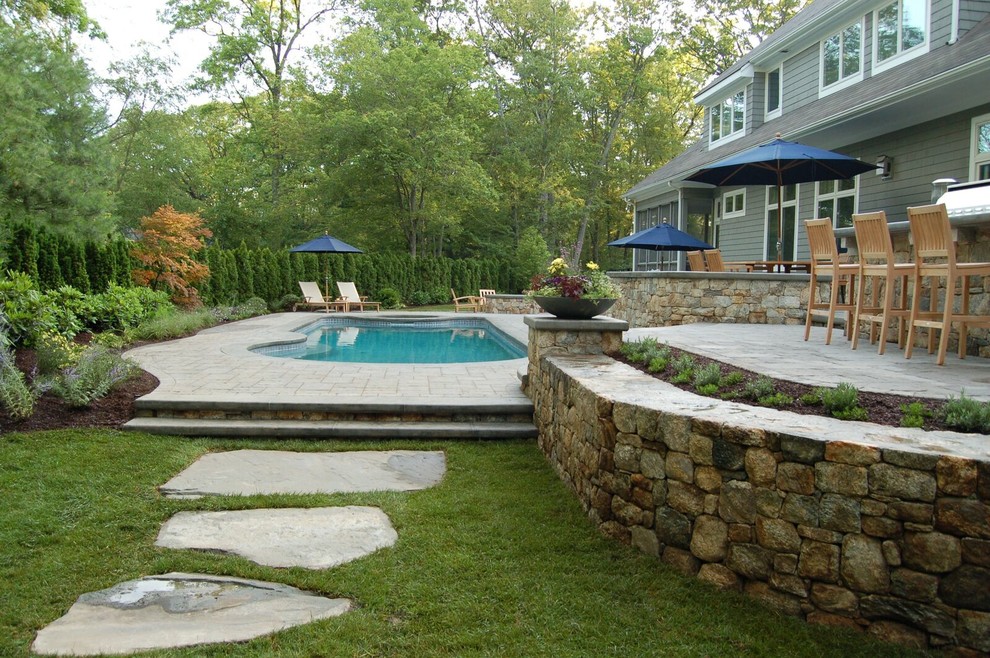 Cette photo montre une piscine arrière chic de taille moyenne et sur mesure avec des pavés en pierre naturelle.
