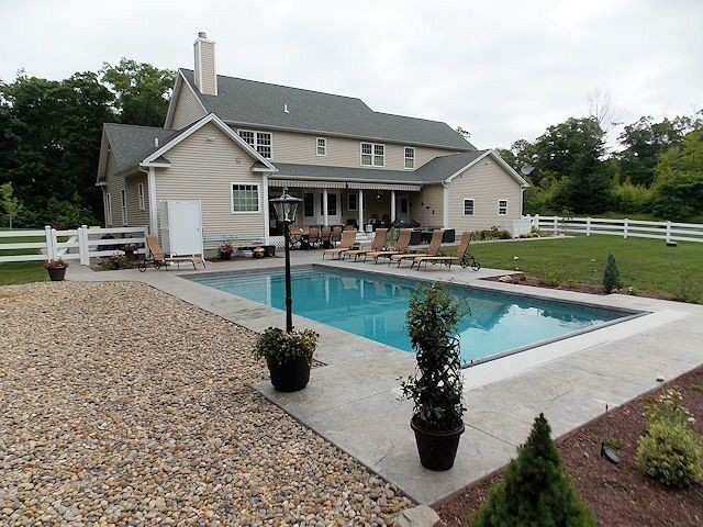 Idee per una piscina country rettangolare di medie dimensioni e dietro casa con cemento stampato
