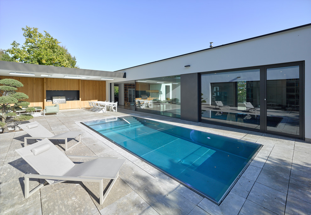 Imagen de piscina contemporánea de tamaño medio rectangular en patio