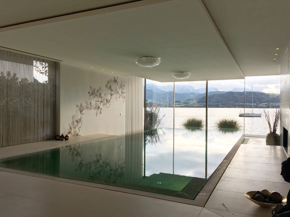 Inspiration for a large world-inspired indoor rectangular infinity swimming pool in Munich.