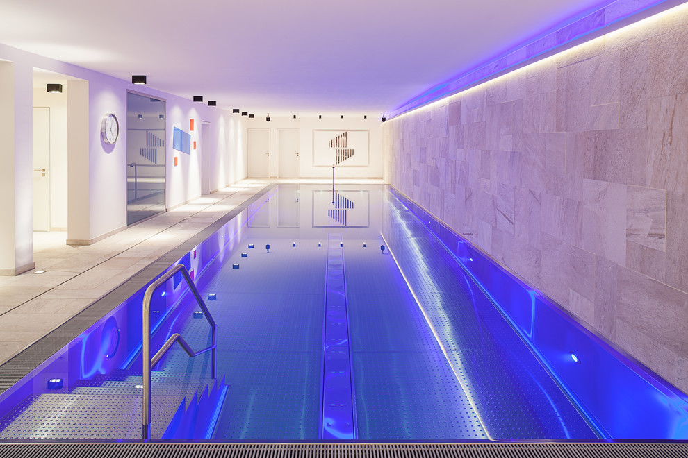 This is an example of a large contemporary indoor rectangular swimming pool in Cologne with tiled flooring.