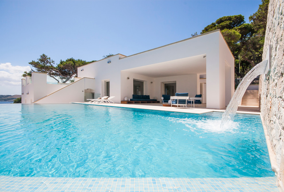 Стильный дизайн: бассейн-инфинити в средиземноморском стиле с фонтаном - последний тренд