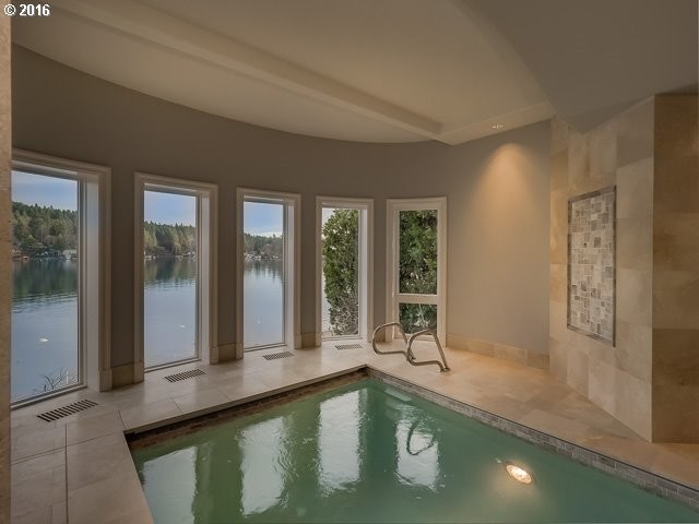 Ejemplo de piscina alargada clásica extra grande rectangular y interior con suelo de baldosas