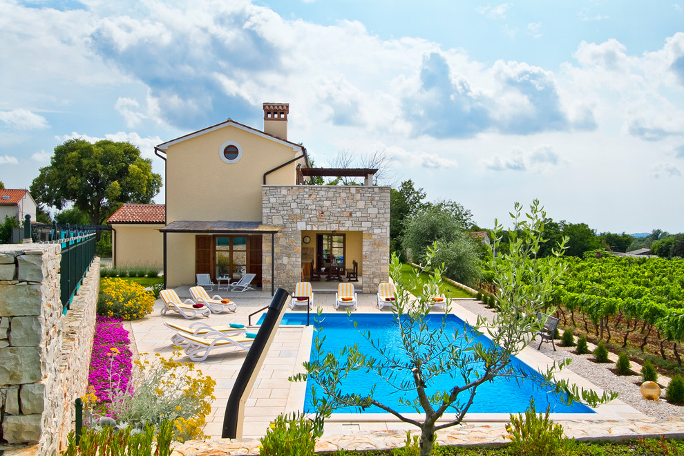 Großer Mediterraner Pool neben dem Haus in rechteckiger Form mit Natursteinplatten in Sonstige