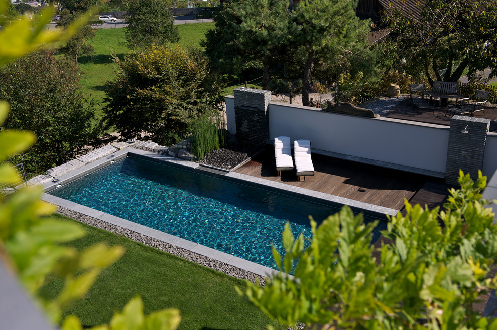 Small contemporary side rectangular lengths swimming pool in Other with decking.