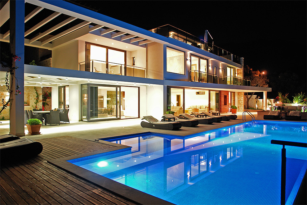 Esempio di una grande piscina design rettangolare dietro casa con pedane