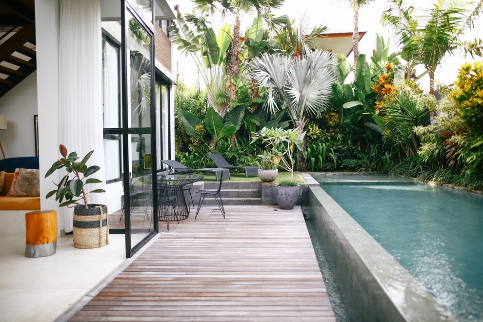 Foto di una piscina a sfioro infinito contemporanea rettangolare dietro casa con pedane