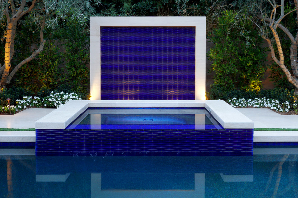 Foto di una piscina a sfioro infinito contemporanea con piastrelle