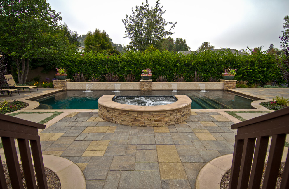 Large transitional backyard concrete paver and custom-shaped lap hot tub photo in Orange County