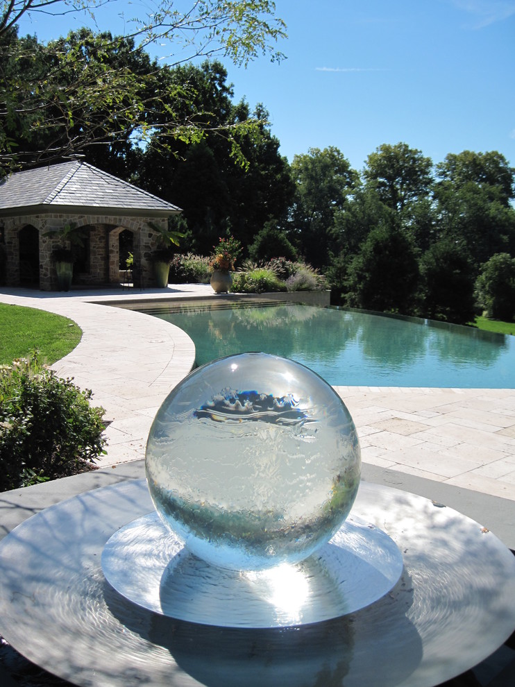 Foto de piscina con fuente infinita tradicional grande a medida en patio trasero con adoquines de piedra natural