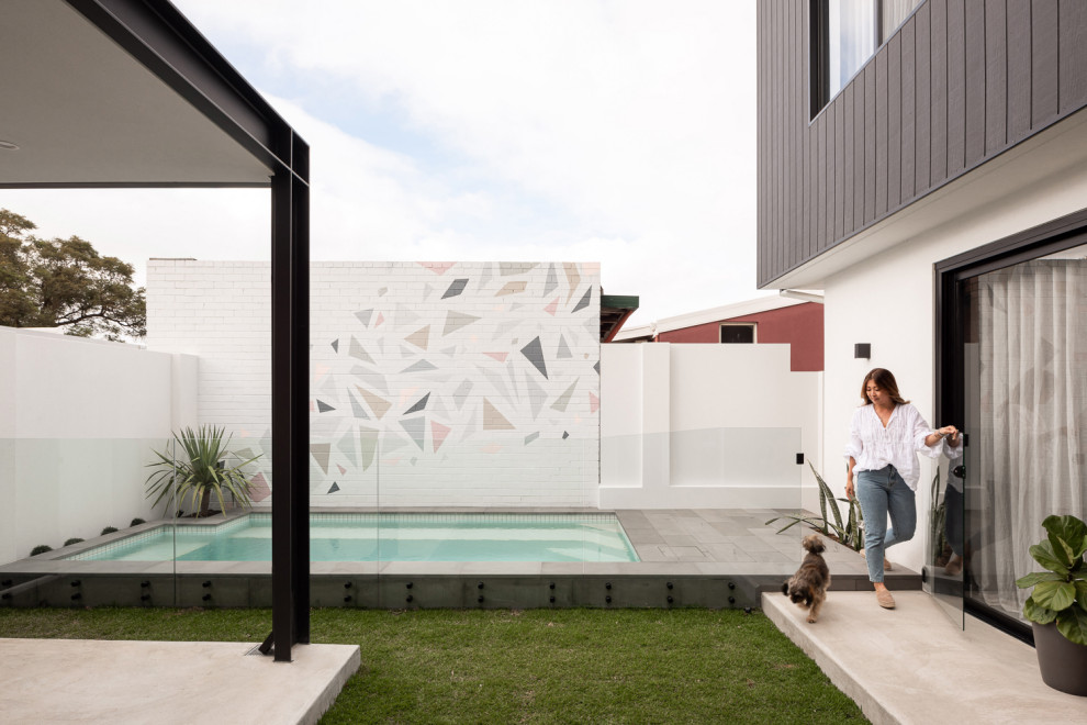 Idee per una piscina moderna rettangolare di medie dimensioni e dietro casa con lastre di cemento