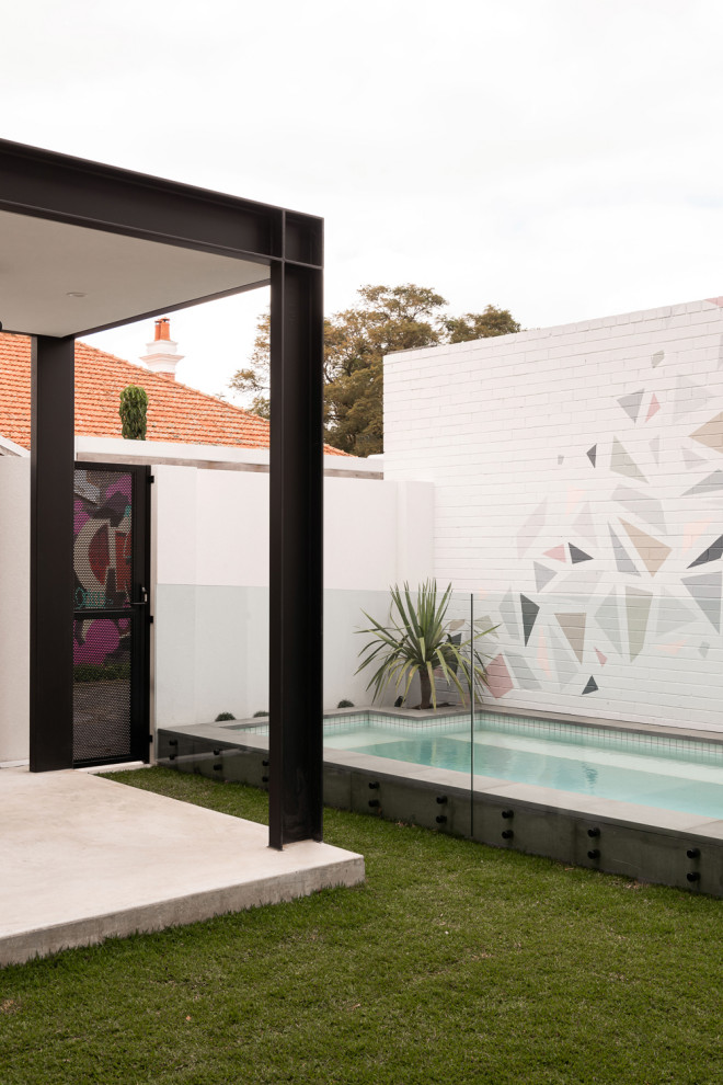 Пример оригинального дизайна: прямоугольный бассейн среднего размера на заднем дворе в стиле модернизм с покрытием из бетонных плит