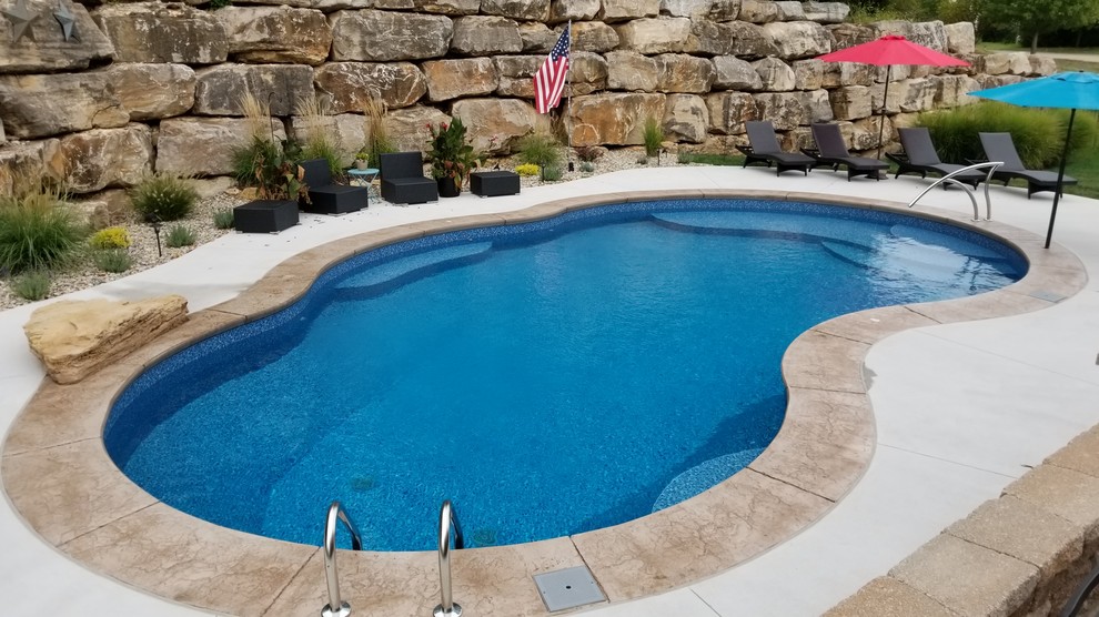 Inspiration för en stor vintage anpassad pool på baksidan av huset, med stämplad betong