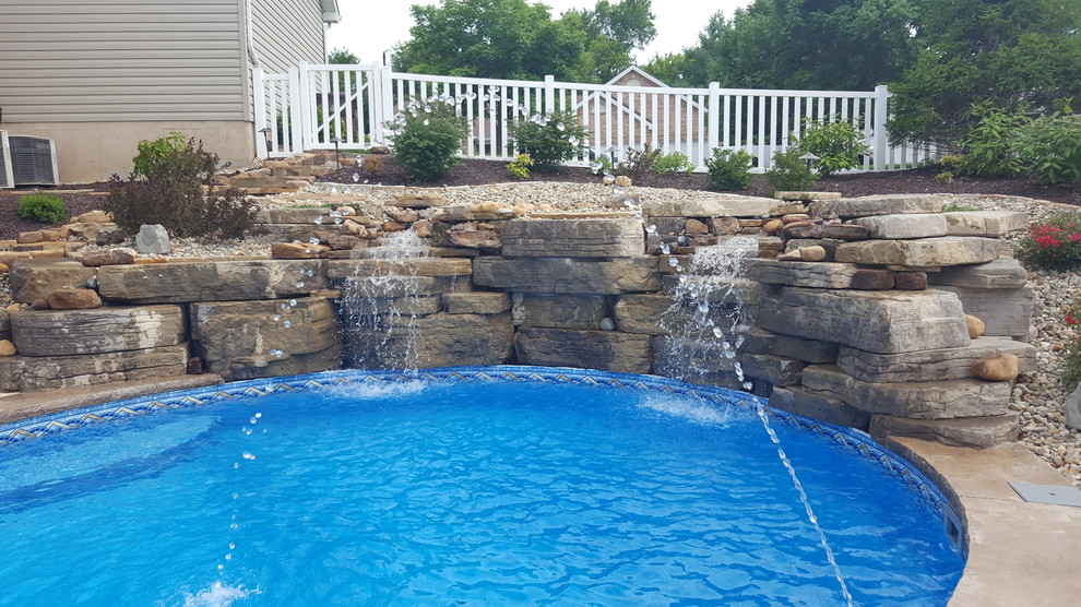 Immagine di una piscina design personalizzata di medie dimensioni e dietro casa con fontane e cemento stampato