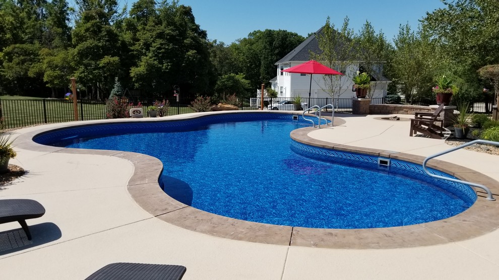 Ispirazione per una grande piscina tradizionale personalizzata dietro casa con cemento stampato