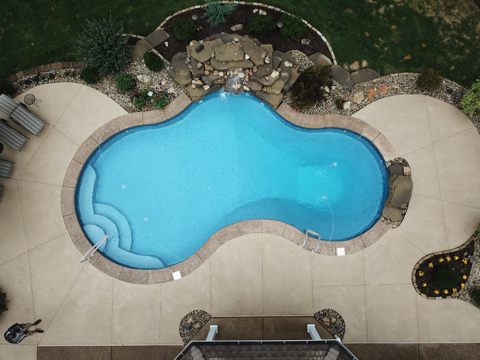 Mittelgroßer Klassischer Schwimmteich hinter dem Haus in individueller Form mit Wasserspiel und Stempelbeton in St. Louis