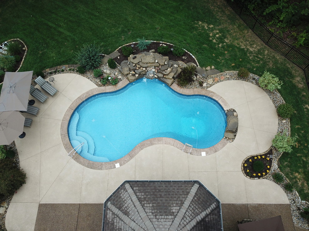 Aménagement d'une piscine naturelle et arrière classique de taille moyenne et sur mesure avec un point d'eau et du béton estampé.