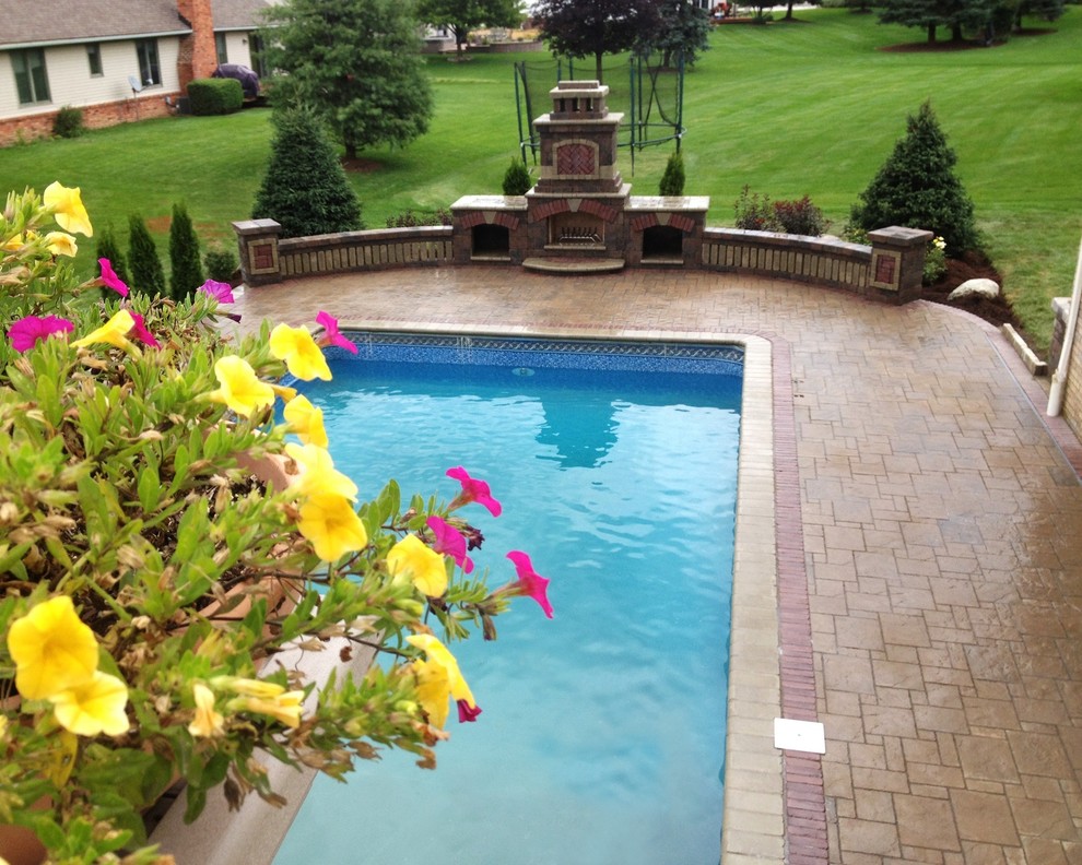 Immagine di una piscina tradizionale personalizzata dietro casa con pavimentazioni in mattoni
