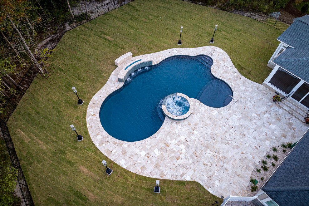 Inspiration pour une piscine design sur mesure avec des pavés en pierre naturelle.