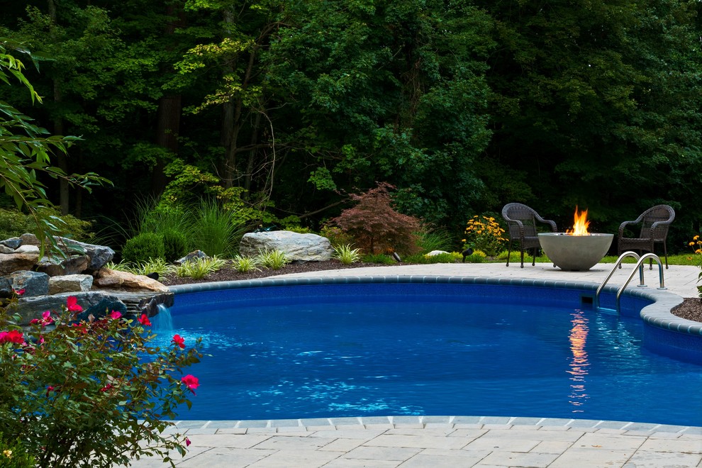 Immagine di una piscina classica personalizzata di medie dimensioni e dietro casa con fontane e pavimentazioni in cemento