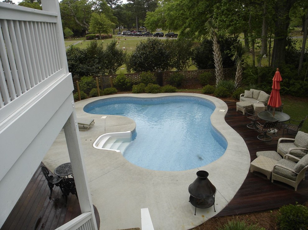 Klassisk inredning av en mellanstor anpassad pool på baksidan av huset