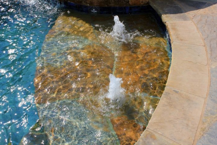 Mittelgroßer Moderner Infinity-Pool hinter dem Haus in individueller Form mit Wasserspiel und Natursteinplatten in Austin