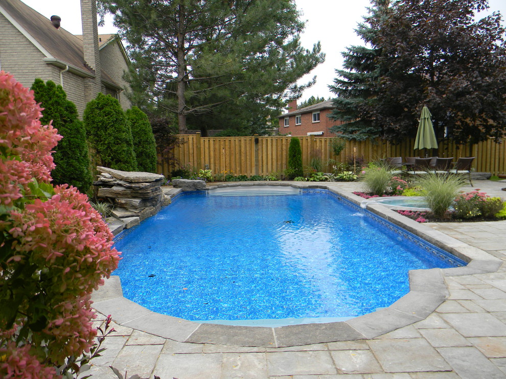 Immagine di una piscina chic rettangolare di medie dimensioni e dietro casa con fontane e pavimentazioni in cemento