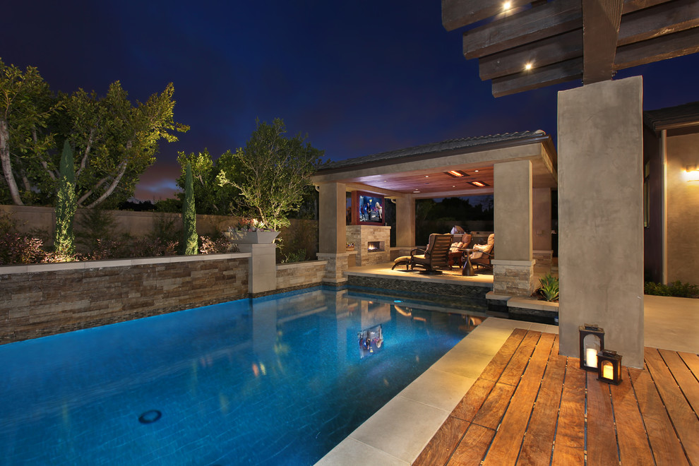 Foto di una piscina design rettangolare di medie dimensioni e dietro casa con pavimentazioni in cemento e una vasca idromassaggio