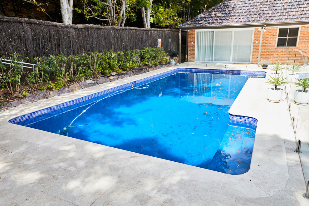 Ejemplo de piscina de tamaño medio rectangular con suelo de baldosas